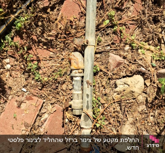 צינור מים עם ברז וחיבורים על אדמה